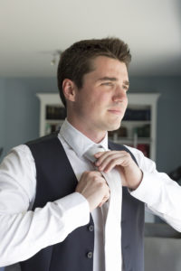 Le futur mari se prépare pour sa journée de mariage et s'habille avec une jolie cravate pour son scostume Photographe mariage Bordeaux Sebastien Huruguen